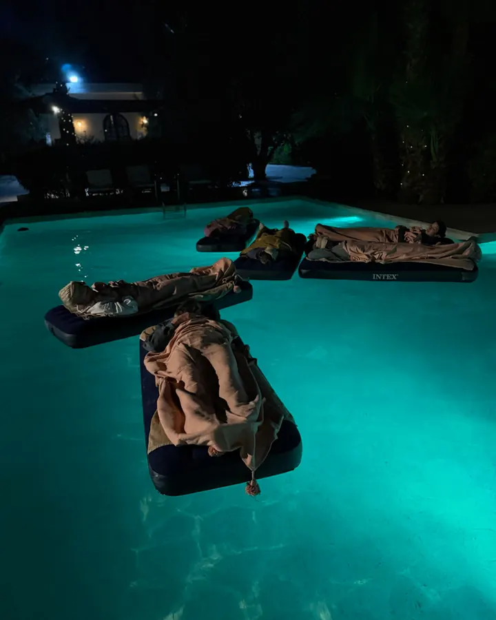Floating day beds on the pool, lit up at night