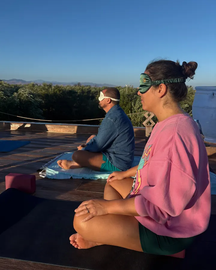 Guests meditating on the roof terrace in eye masks