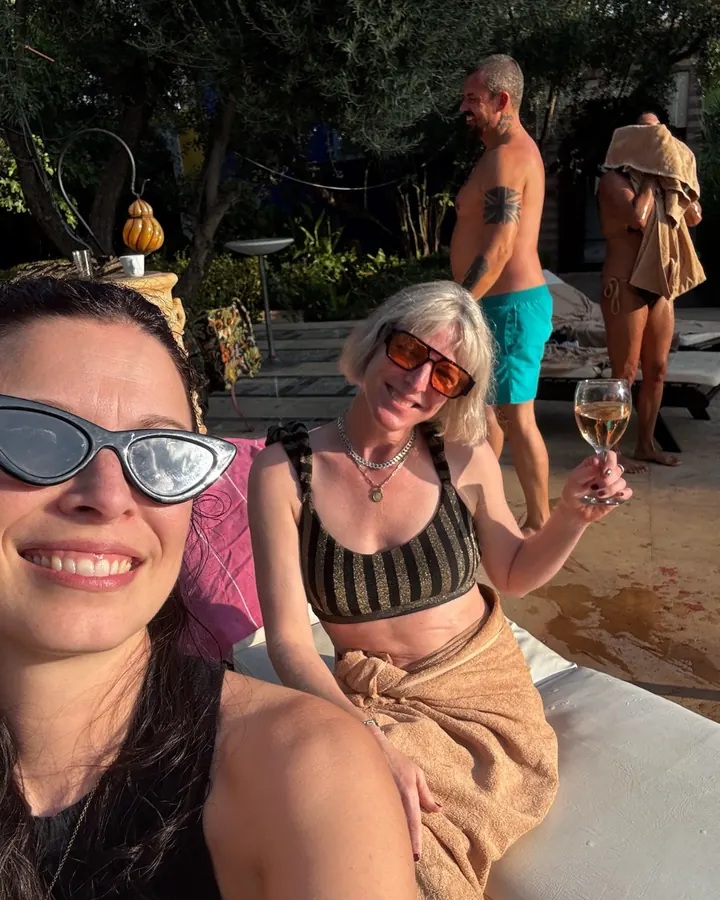 Guests by the pool with a glass of wine
